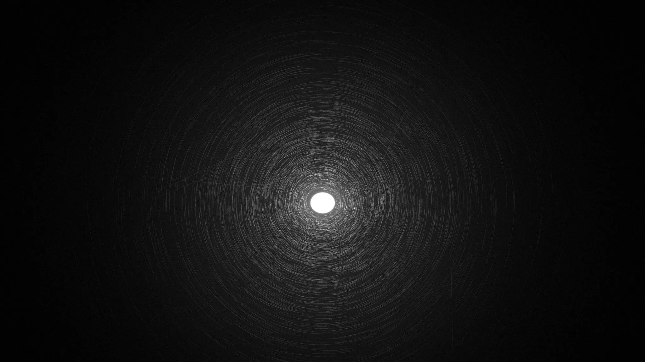 Before paint correction: swirl marks circling an inspection light on a black panel